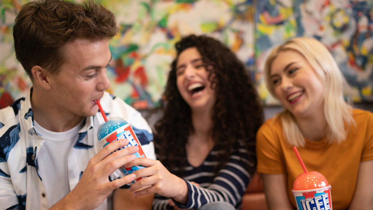 A group of people enjoying some ICEE, a sugary, frozen drink.