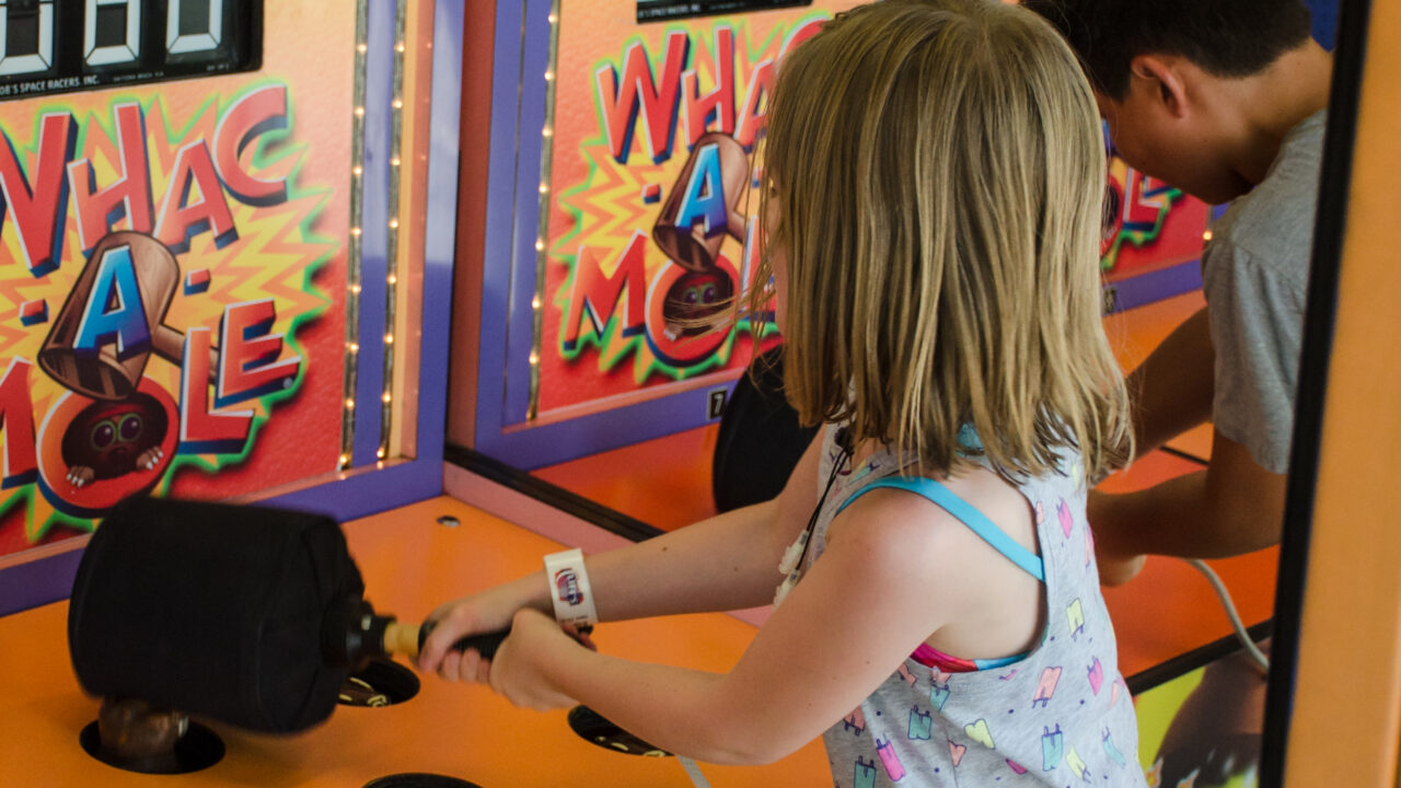 Little girl playing Whack Mole.